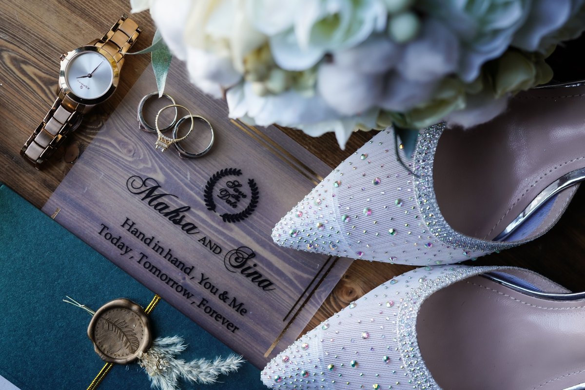 Engraved wooden save the date sign with wedding rings and bridal shoes, illustrating when couples should send save the dates before the wedding