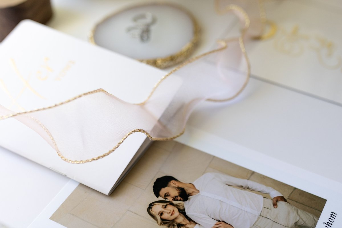 Wedding vow book with a printed photo card and gold-edged ribbon, part of a complete wedding stationery suite