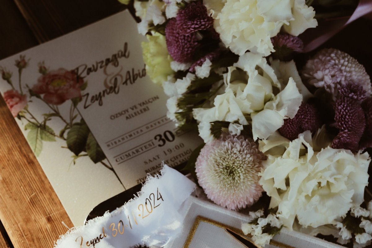 Wedding invitation displaying the ceremony date and day of the week beside a bouquet, an example of how to write the date on a formal wedding invitation