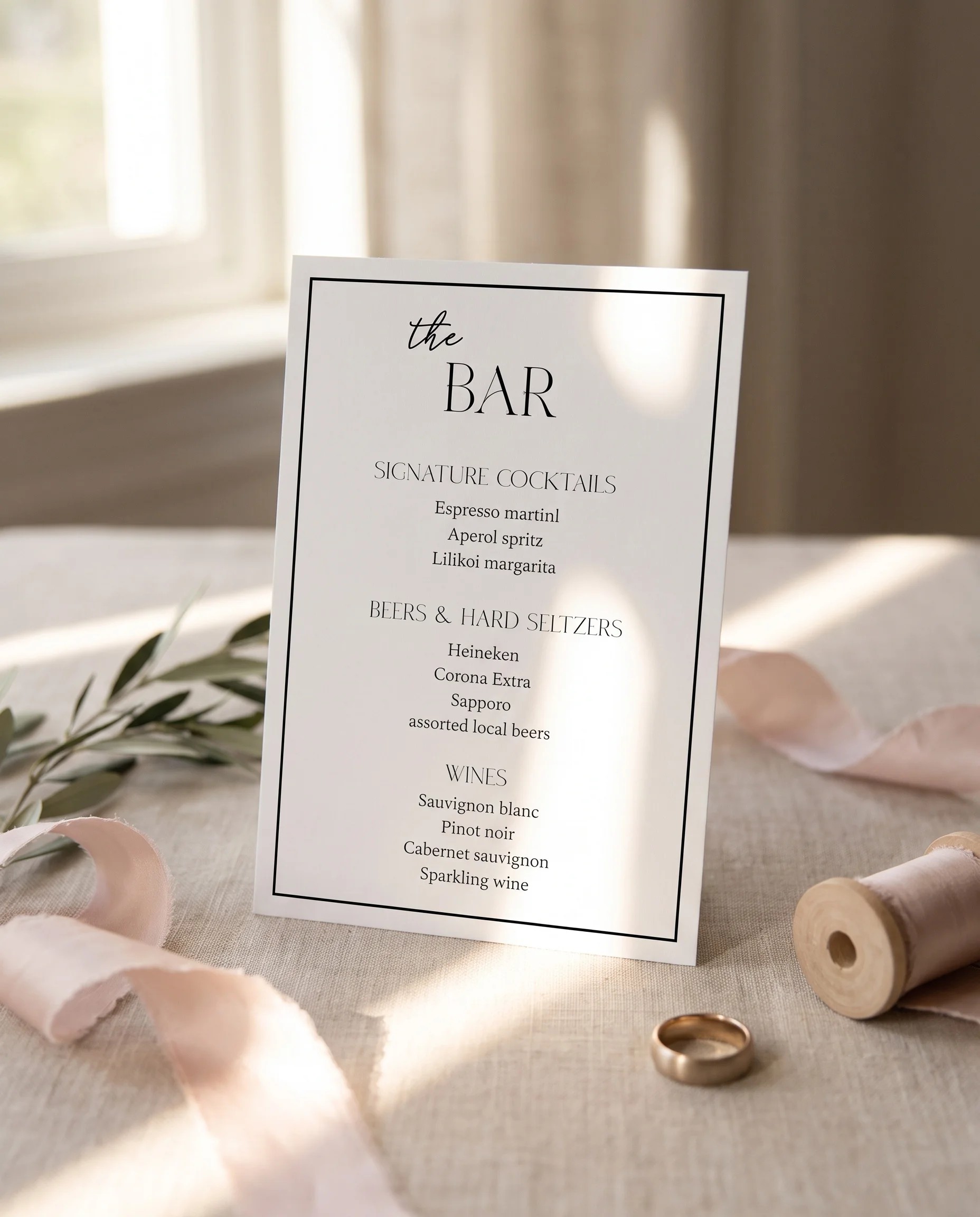 Aurelian — Bar Menu displayed upright on premium editorial paper under soft natural light at a slight overhead angle, wedding bar sign.