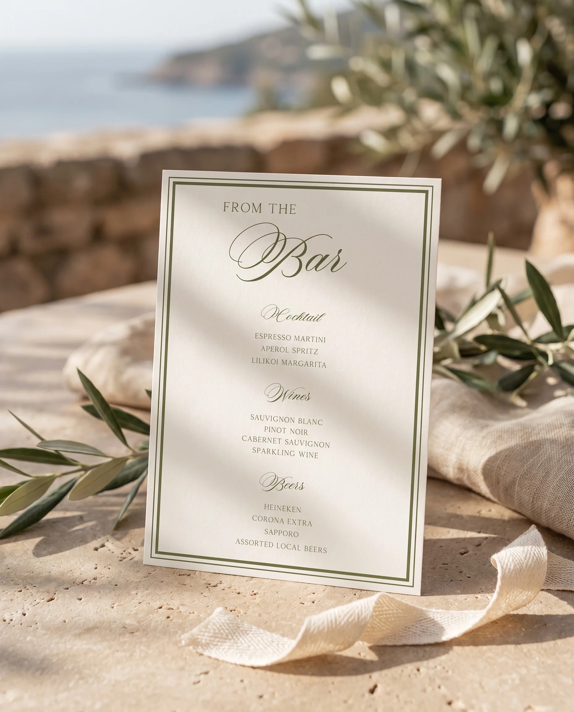 Olive Script — bar menu displayed upright under soft natural light on premium editorial paper, wedding bar sign.